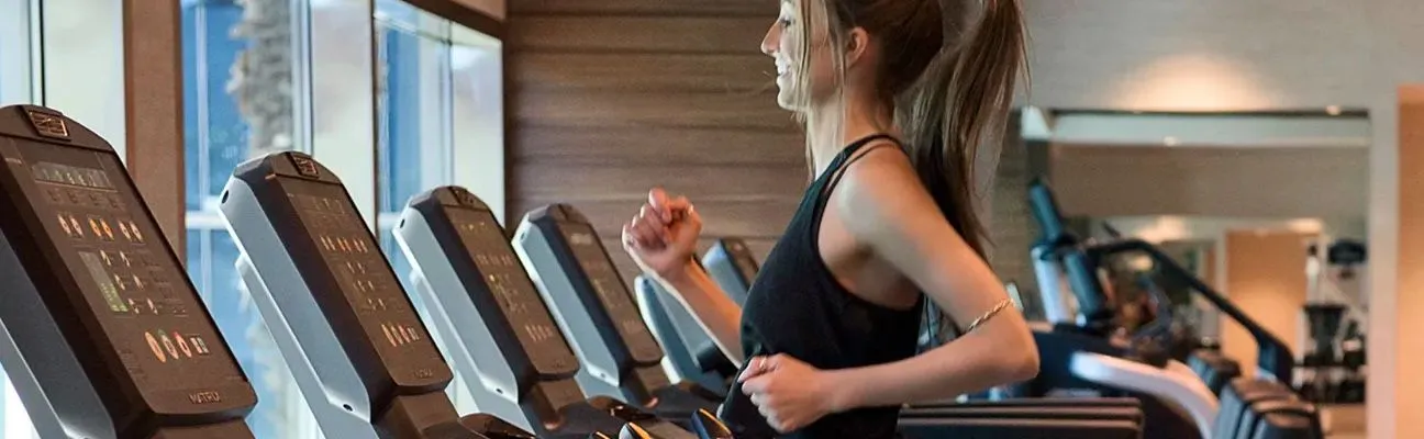 Persone che corrono sui tapis roulant in palestra