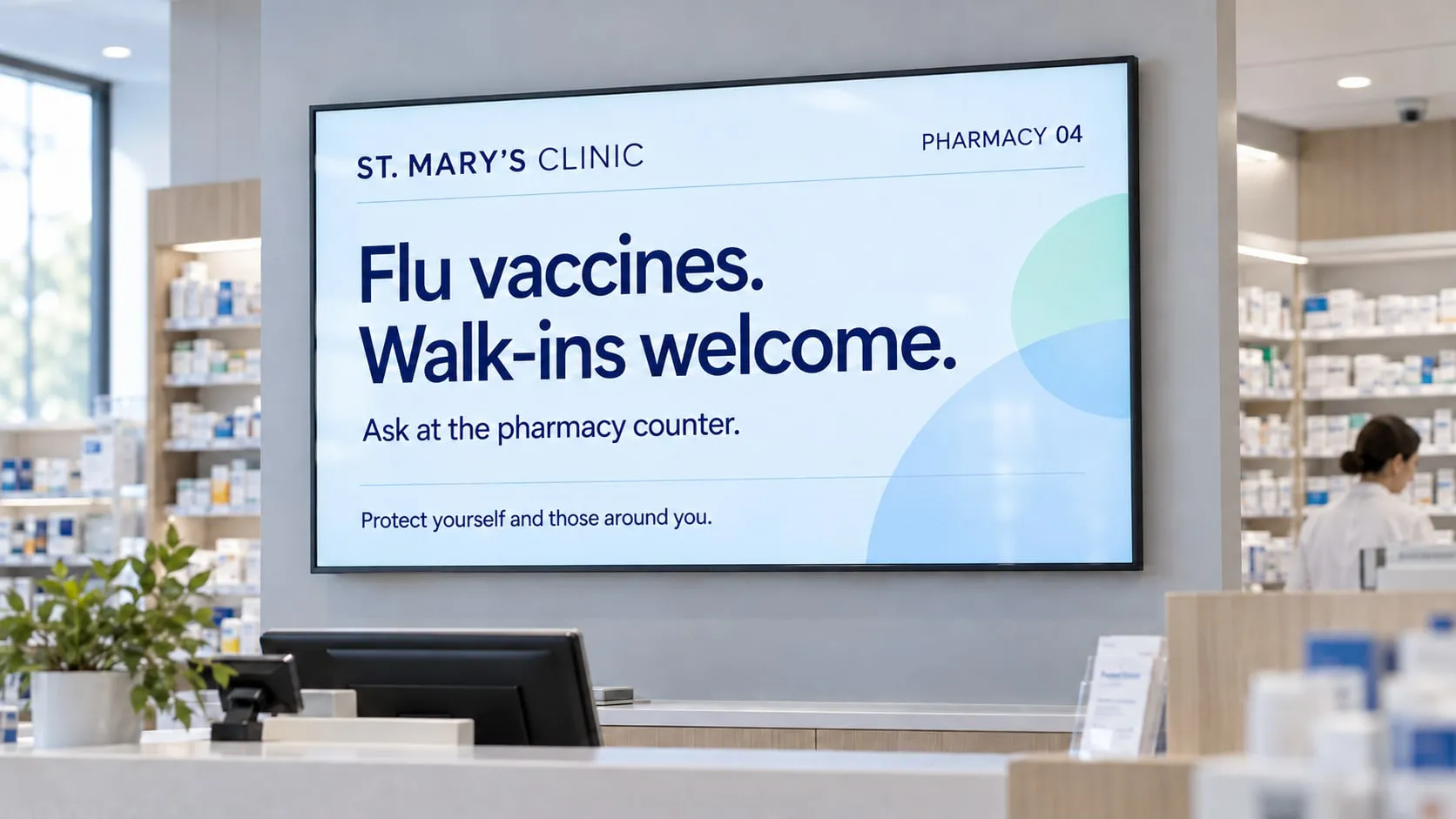 Banco di una farmacia con uno schermo che annuncia i vaccini antinfluenzali, anche senza appuntamento