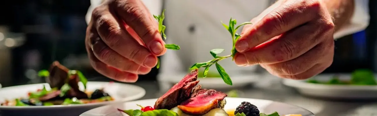Chef che impiatta una portata nella cucina di un ristorante