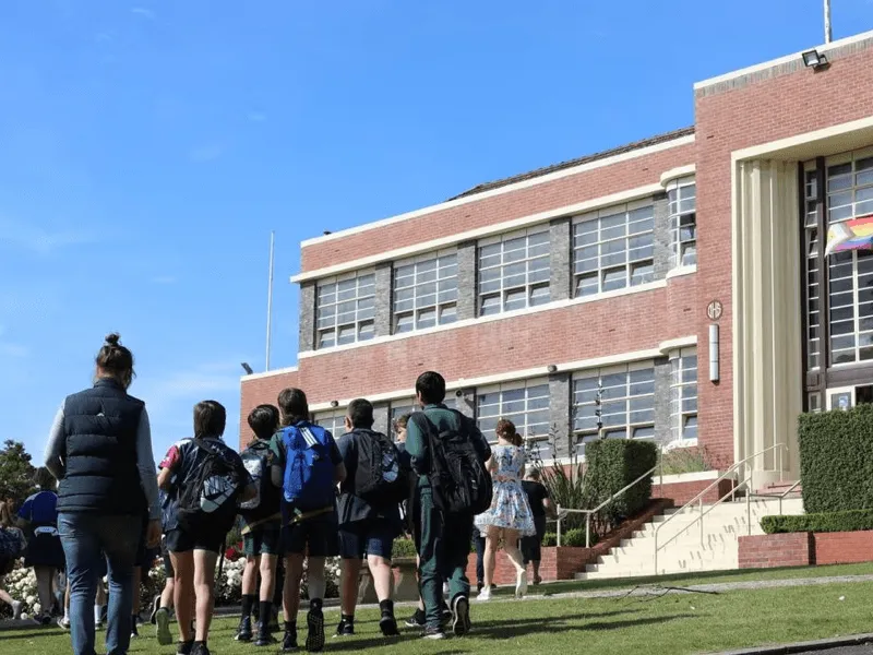 Studenti che camminano verso un edificio scolastico